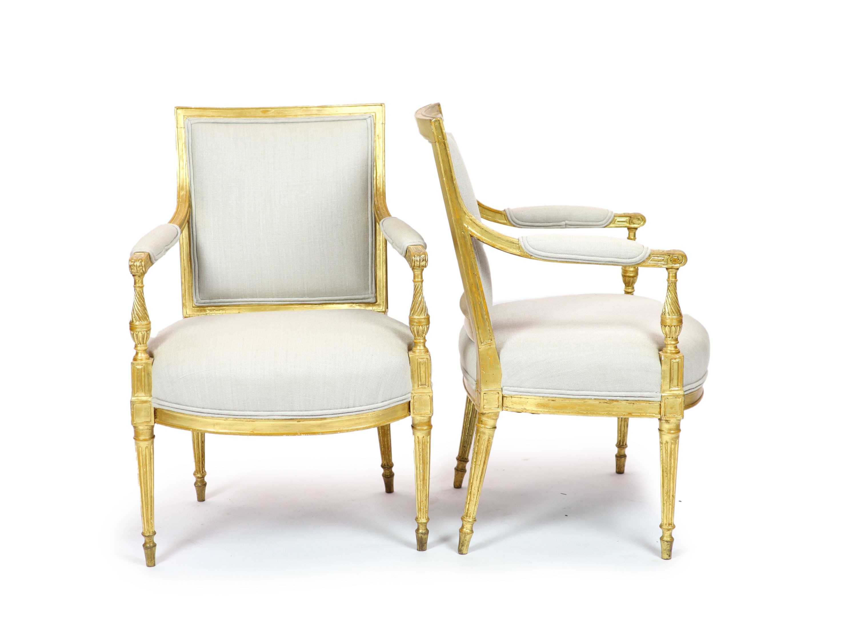 A pair of Louis XVI style giltwood elbow chairs H 89cm. W 59cm. D 60cm.